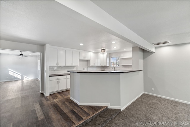 kitchen with white cabinetry, kitchen peninsula, sink, and backsplash