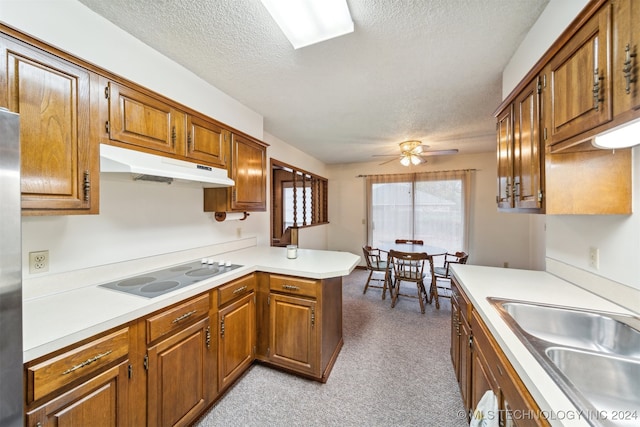 kitchen featuring light carpet, white electric cooktop, a textured ceiling, and kitchen peninsula