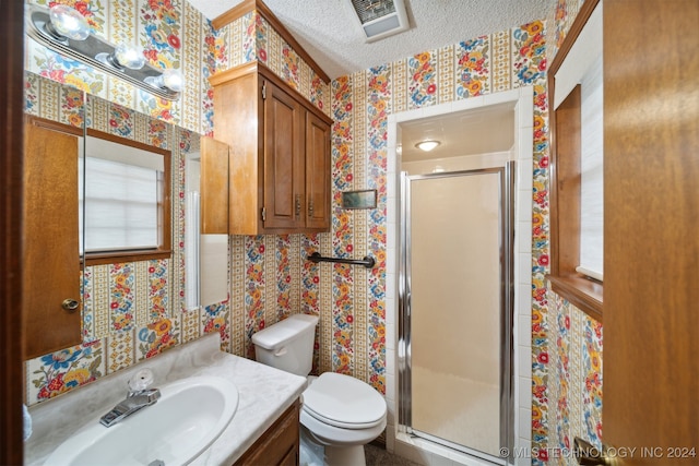 bathroom featuring vanity, a textured ceiling, toilet, and an enclosed shower