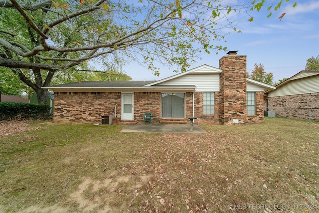 rear view of property with a patio and a yard