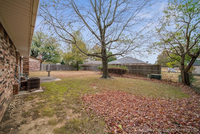 view of yard with central air condition unit and a patio area