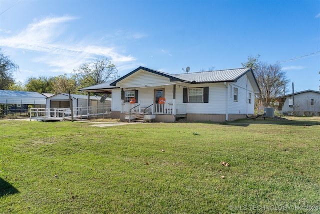 view of front facade with central AC unit, a porch, and a front lawn