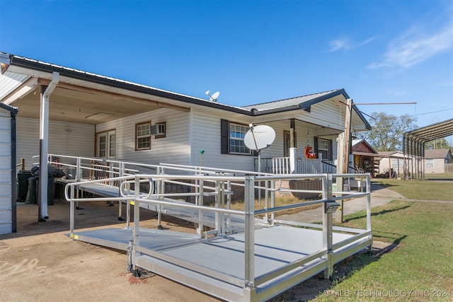 view of front facade with an AC wall unit and covered porch