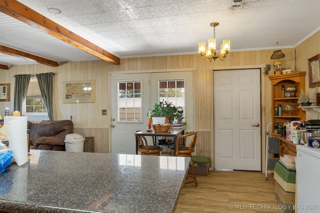 kitchen with beam ceiling, wooden walls, hanging light fixtures, and an inviting chandelier