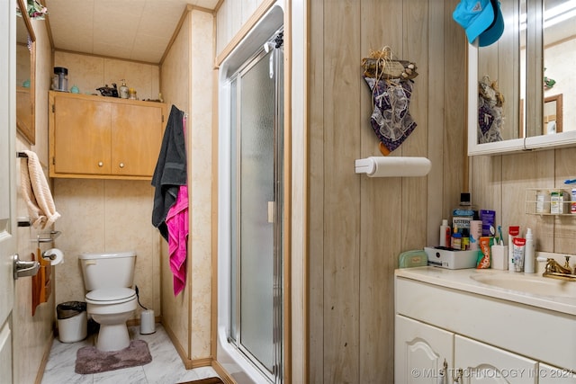 bathroom featuring vanity, wood walls, toilet, and a shower with door