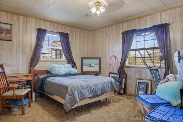 carpeted bedroom with wood walls