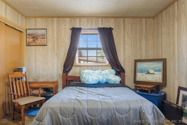 carpeted bedroom with wooden walls and ornamental molding