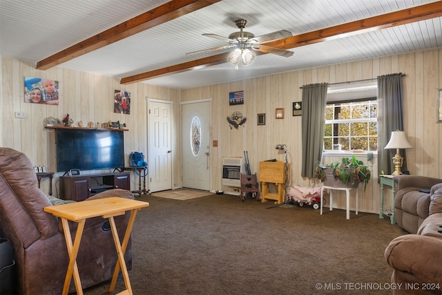 carpeted living room with ceiling fan, beam ceiling, wooden walls, and heating unit