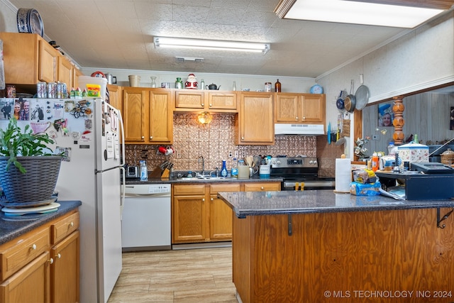 kitchen with tasteful backsplash, white appliances, crown molding, sink, and light hardwood / wood-style floors