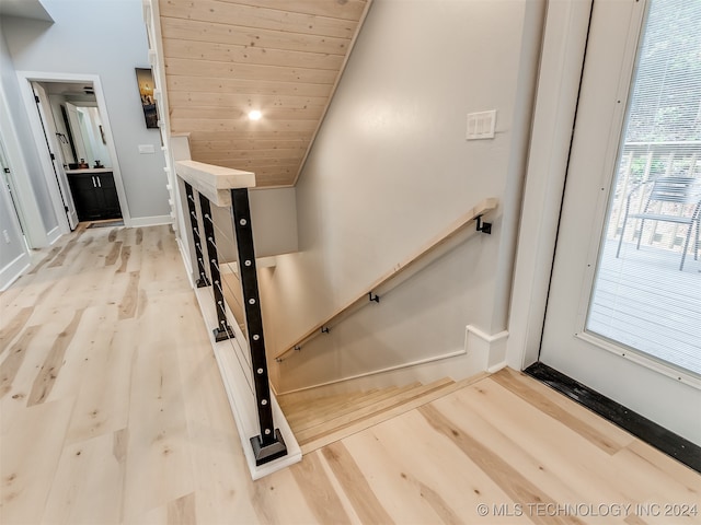 staircase with wooden ceiling, vaulted ceiling, and hardwood / wood-style floors