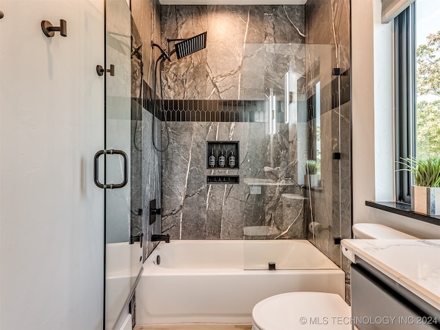 full bathroom featuring vanity, toilet, and shower / bath combination with glass door