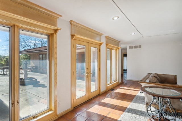 doorway to outside featuring lofted ceiling, french doors, and tile patterned floors