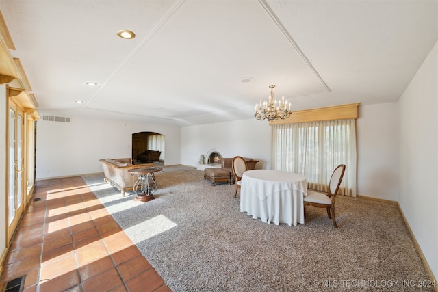 carpeted dining space with an inviting chandelier