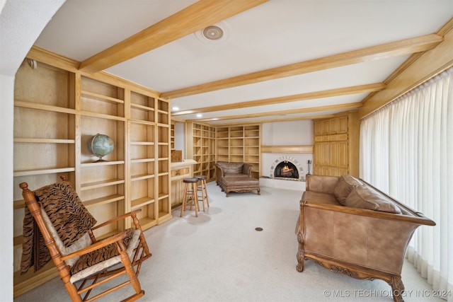 living area featuring carpet, beamed ceiling, and built in shelves