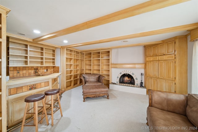 carpeted living room featuring beam ceiling and indoor bar