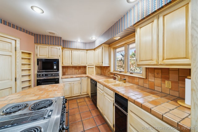 kitchen with tile patterned floors, tile countertops, sink, black appliances, and tasteful backsplash