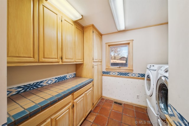 clothes washing area with washing machine and dryer and cabinets