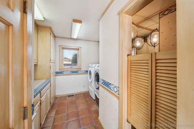 washroom with independent washer and dryer and dark tile patterned floors