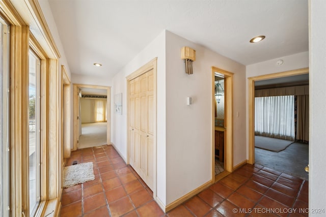 hall featuring dark colored carpet