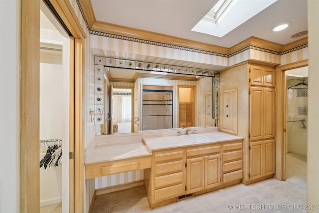 bathroom featuring vanity, crown molding, and a skylight