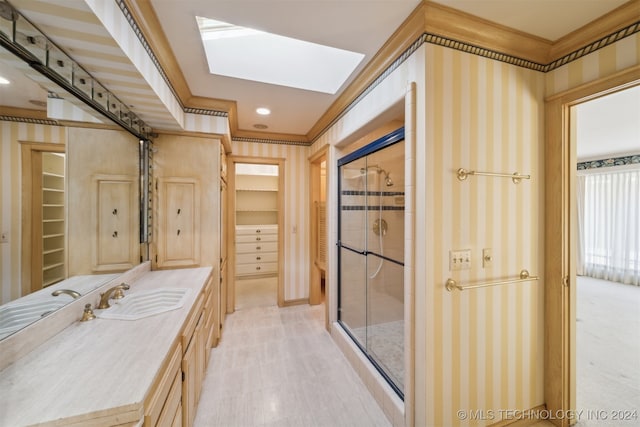 bathroom featuring a shower with door, vanity, ornamental molding, and a skylight