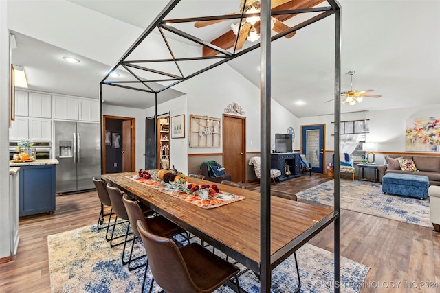 dining space with vaulted ceiling, light wood-type flooring, and ceiling fan