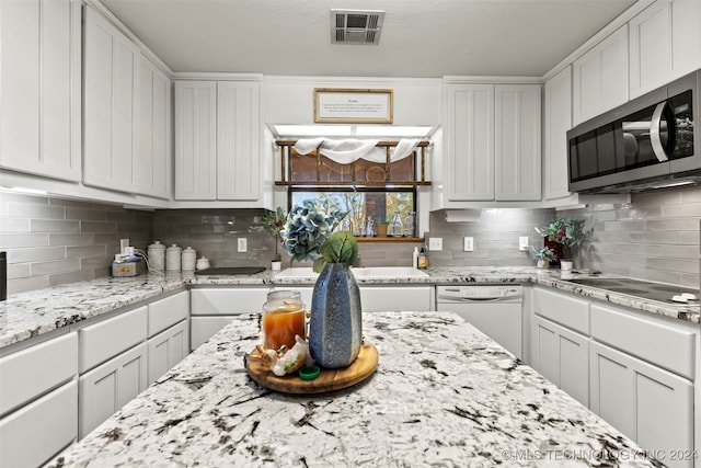 kitchen featuring white dishwasher, decorative backsplash, white cabinets, and cooktop