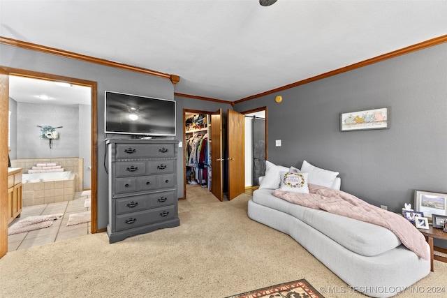 carpeted bedroom featuring a closet, a walk in closet, ensuite bath, and crown molding