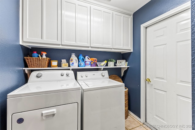 laundry area with independent washer and dryer, light tile patterned floors, and cabinets