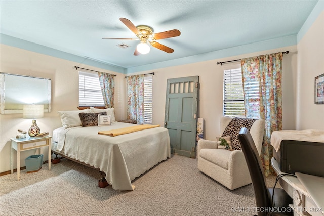 bedroom with a textured ceiling, carpet flooring, and ceiling fan