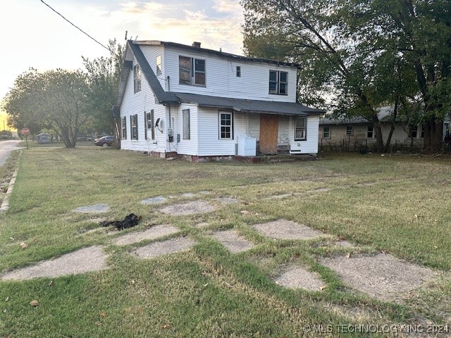 rear view of property featuring a lawn