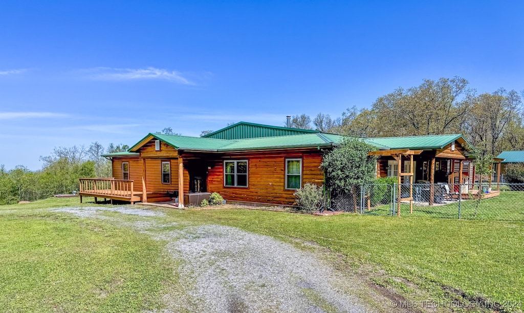 cabin featuring a front yard and a wooden deck