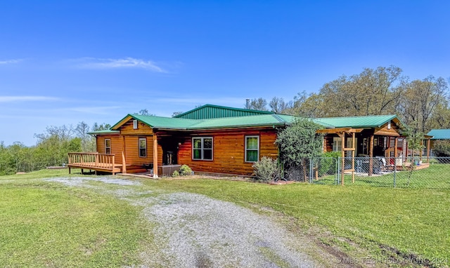 cabin featuring a front yard and a wooden deck