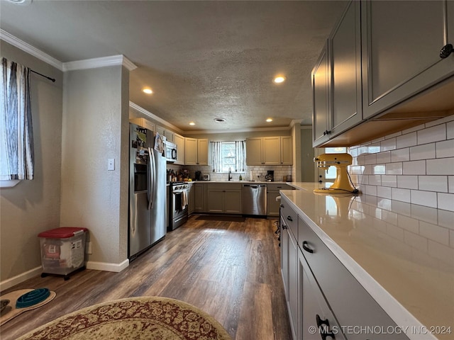 kitchen with sink, gray cabinetry, dark hardwood / wood-style floors, stainless steel appliances, and decorative backsplash