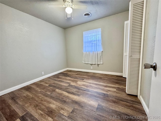 unfurnished bedroom featuring a closet, a textured ceiling, dark hardwood / wood-style floors, and ceiling fan