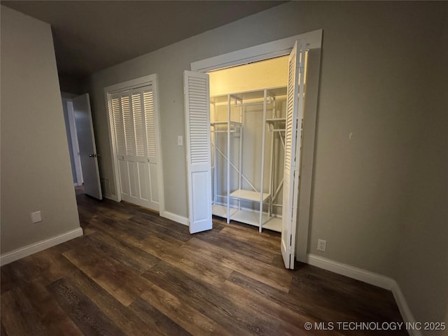 unfurnished bedroom featuring dark wood-type flooring and a closet