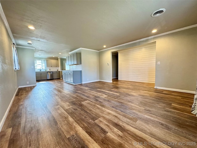 unfurnished living room featuring dark hardwood / wood-style flooring, sink, and crown molding