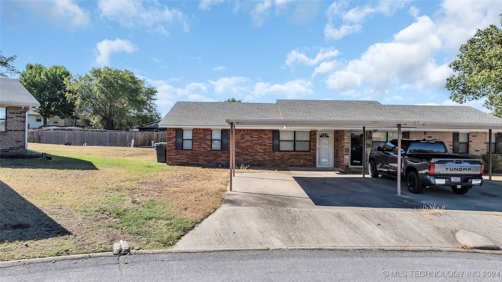 ranch-style home featuring a front yard and a carport