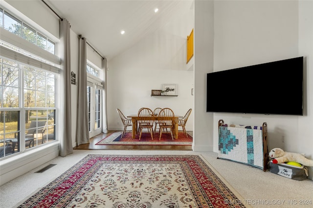 carpeted living room featuring high vaulted ceiling