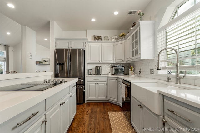 kitchen with white cabinets, plenty of natural light, black appliances, and dark hardwood / wood-style floors