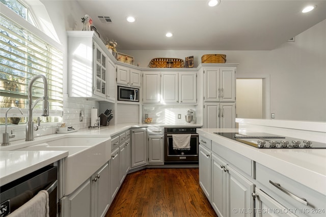 kitchen with dark hardwood / wood-style flooring, white cabinets, sink, backsplash, and appliances with stainless steel finishes