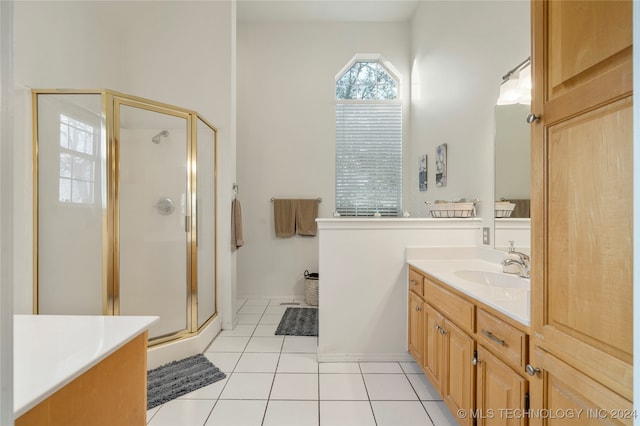 bathroom featuring a shower with shower door, vanity, and tile patterned floors