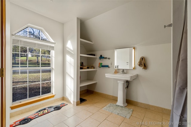 bathroom with vaulted ceiling and tile patterned floors