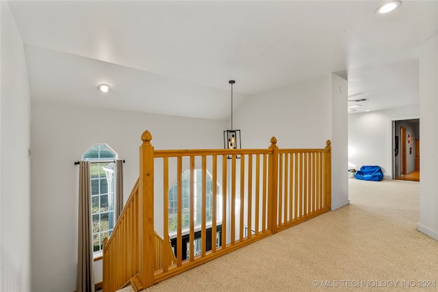 corridor featuring carpet floors and vaulted ceiling