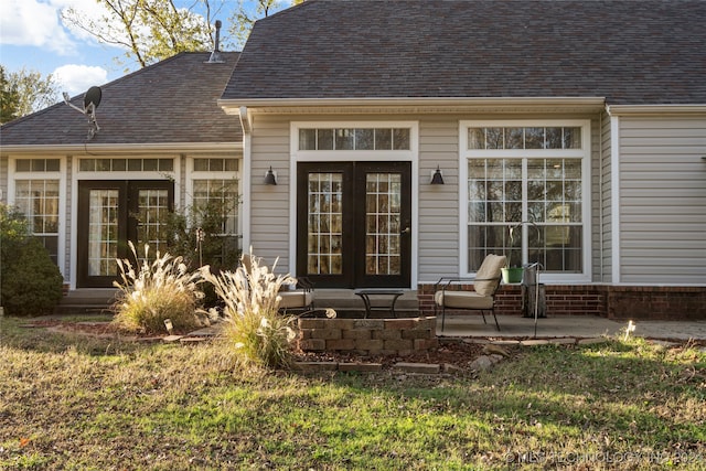 property entrance featuring french doors, a lawn, and a patio