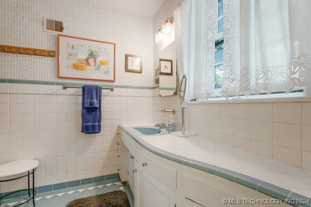 bathroom with vanity, tile patterned floors, and tile walls