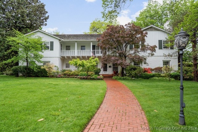 view of front of home with a front lawn and a balcony