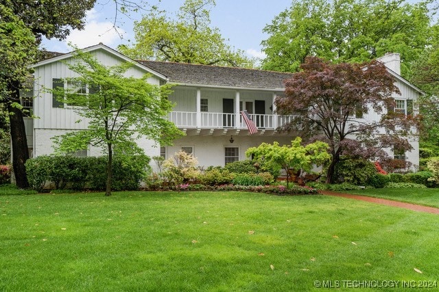 view of front of home with a front lawn and a balcony