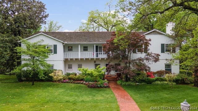 view of front of property with a front yard and a balcony