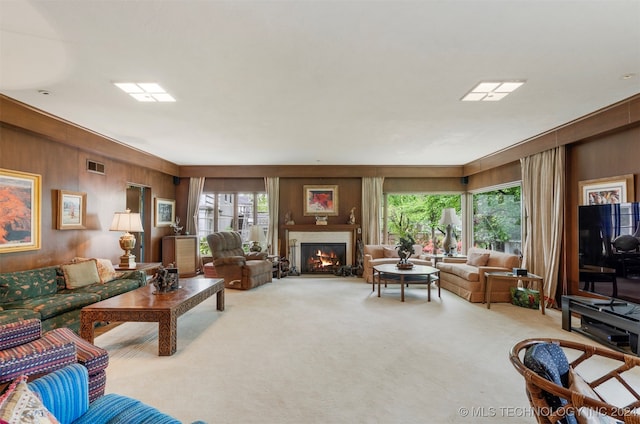 living room with wood walls, carpet, and plenty of natural light